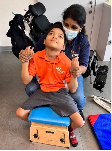 (Left) Ms Sheila supporting her student during a mobility training session, and (right) sharing with a student’s caregiver how the use of picture cards can support communication with the child. Picture 2